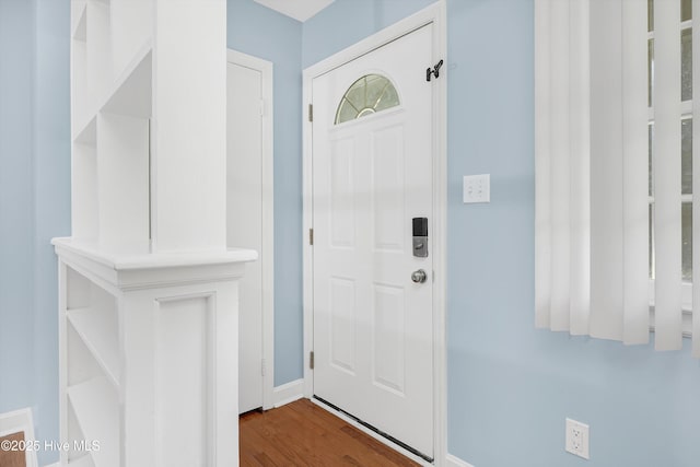 entryway featuring baseboards and dark wood-type flooring