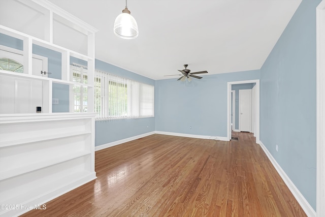 unfurnished living room featuring baseboards, ceiling fan, and wood finished floors