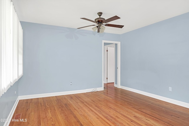 empty room with baseboards, ceiling fan, and light wood-style flooring