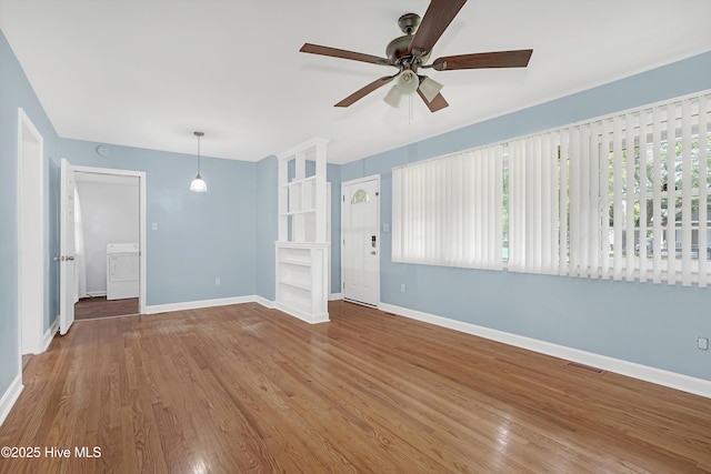 unfurnished living room featuring visible vents, wood finished floors, baseboards, washer / clothes dryer, and ceiling fan