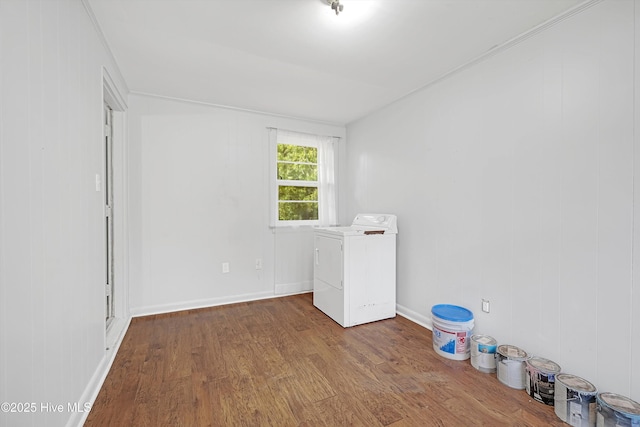empty room with baseboards, washer / dryer, and wood finished floors