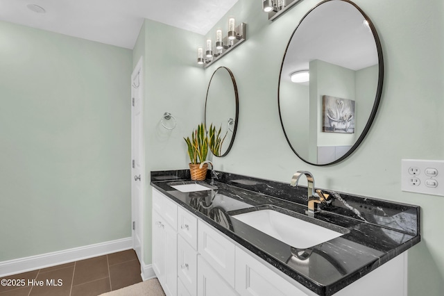 bathroom with double vanity, baseboards, a sink, and tile patterned floors
