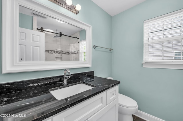 full bath with visible vents, vanity, toilet, baseboards, and a tile shower