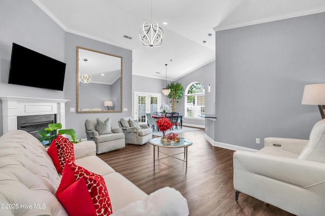 living area with crown molding, baseboards, lofted ceiling, and wood finished floors