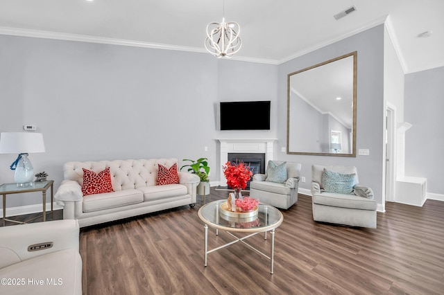 living area with crown molding, a fireplace, baseboards, wood finished floors, and visible vents