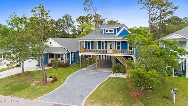 226 NE 64th St, Oak Island, NC 28465 - raised beach house featuring a porch, a carport, gravel driveway, and a front lawn