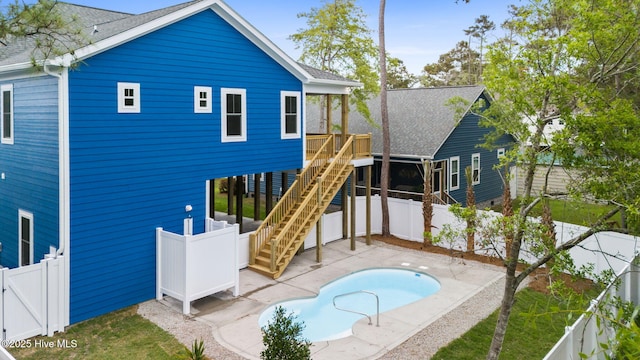 226 NE 64th St, Oak Island, NC 28465 - rear view of house with a patio area, a fenced backyard, stairs, and roof with shingles