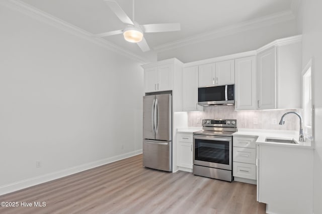 226 NE 64th St, Oak Island, NC 28465 - kitchen featuring stainless steel appliances, a sink, tasteful backsplash, white cabinetry, and crown molding