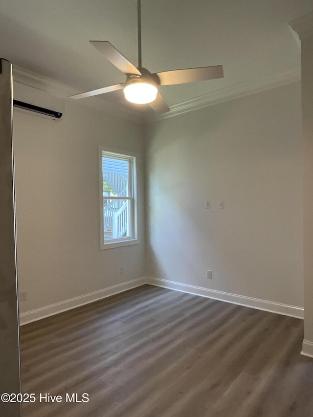 spare room with baseboards, ornamental molding, dark wood-style flooring, and a ceiling fan