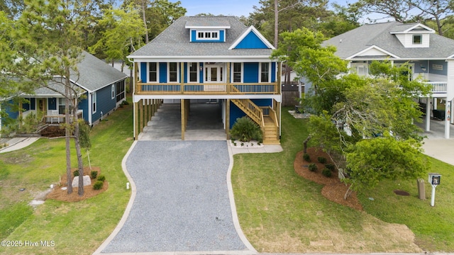 226 NE 64th St, Oak Island, NC 28465 - beach home featuring a carport, covered porch, driveway, and a front lawn