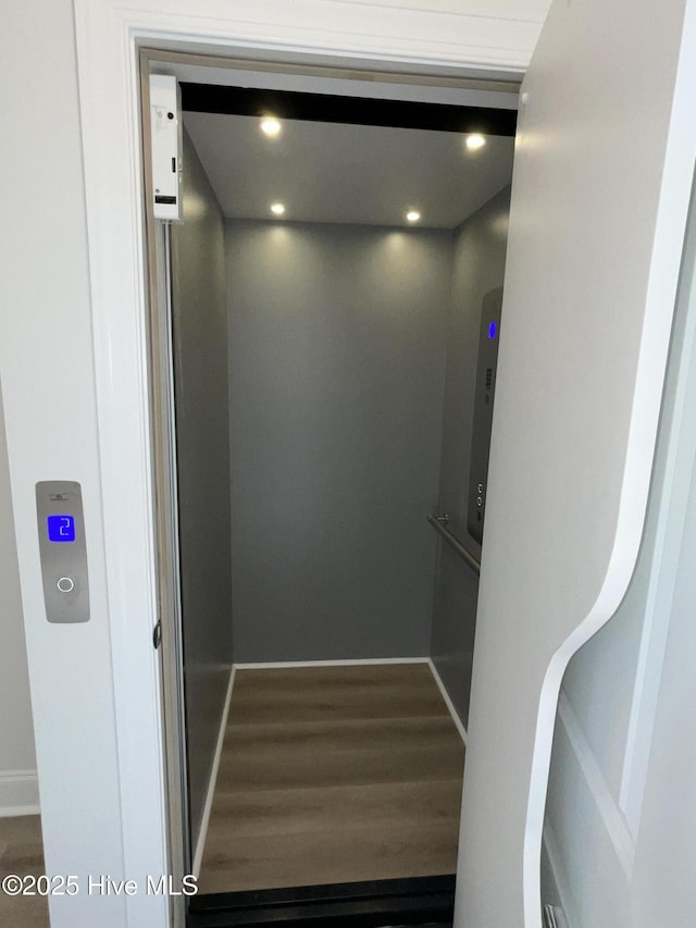 interior space with dark wood-type flooring and elevator