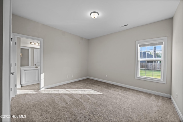 unfurnished bedroom featuring baseboards, carpet flooring, connected bathroom, and visible vents