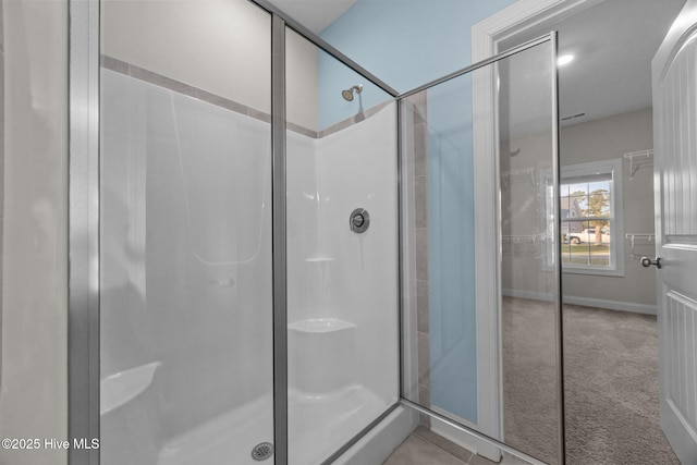 bathroom featuring baseboards and a shower stall