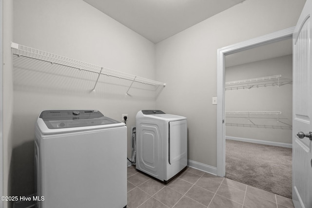 washroom with laundry area, washing machine and dryer, light tile patterned flooring, baseboards, and light colored carpet