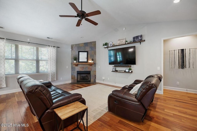 living room featuring baseboards, ceiling fan, wood finished floors, and lofted ceiling
