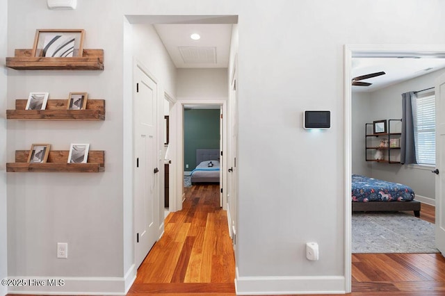 corridor featuring baseboards and wood finished floors