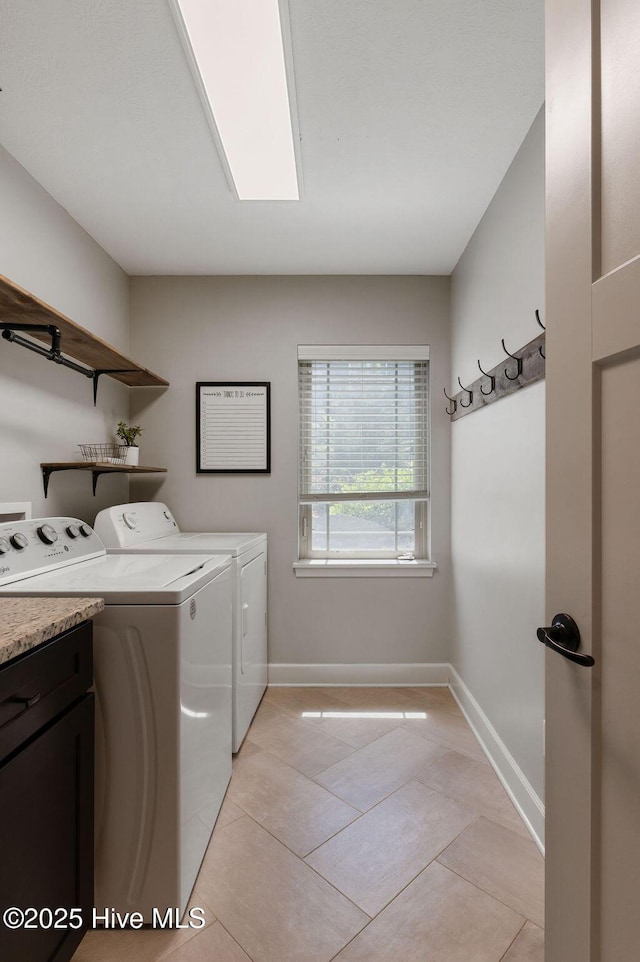 clothes washing area with baseboards, cabinet space, independent washer and dryer, and light tile patterned flooring