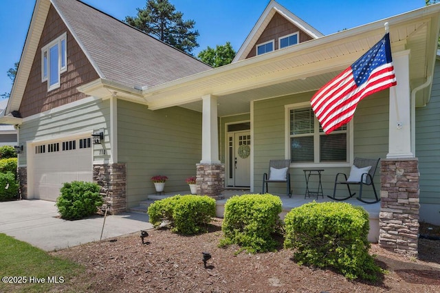 craftsman house with a porch, concrete driveway, an attached garage, a shingled roof, and stone siding