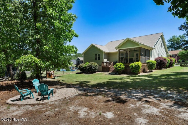 rear view of property featuring a lawn, a ceiling fan, stairs, and fence