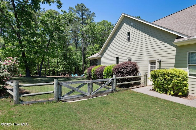 view of home's exterior with a gate, fence, and a yard