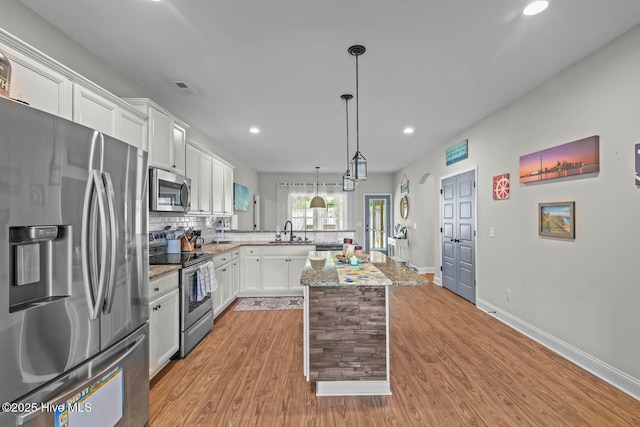 kitchen featuring tasteful backsplash, light wood-type flooring, stainless steel appliances, and recessed lighting