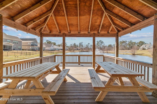 deck with a gazebo, a water view, outdoor dining area, and a residential view