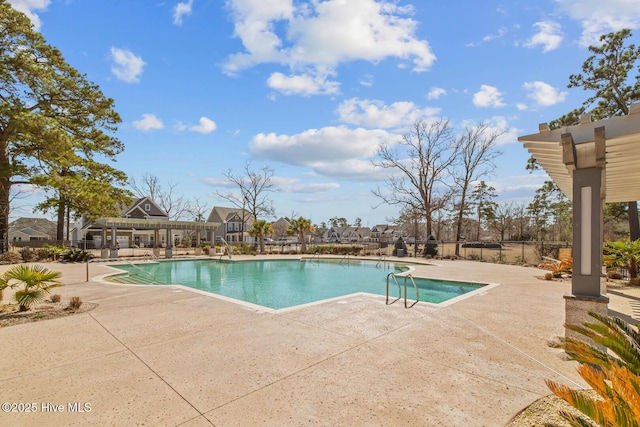 community pool with a patio area and fence
