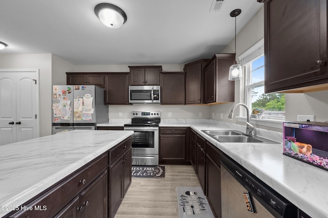 kitchen with visible vents, dark brown cabinetry, light wood-style floors, a sink, and appliances with stainless steel finishes