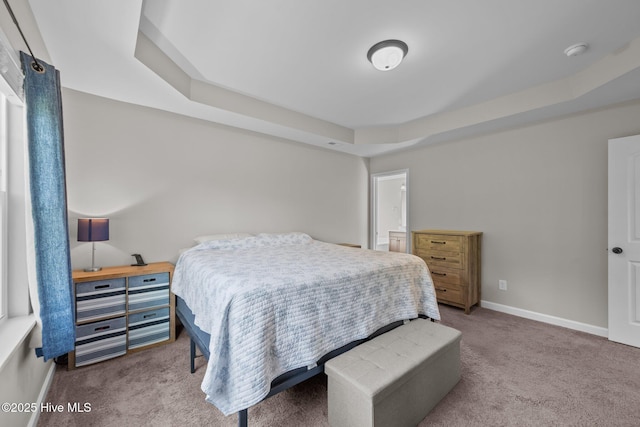 bedroom with baseboards, carpet flooring, and a tray ceiling