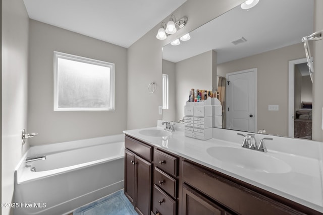 full bathroom featuring a sink, double vanity, a bath, and visible vents