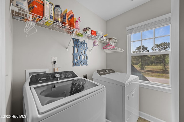 clothes washing area featuring baseboards, laundry area, and washer and clothes dryer