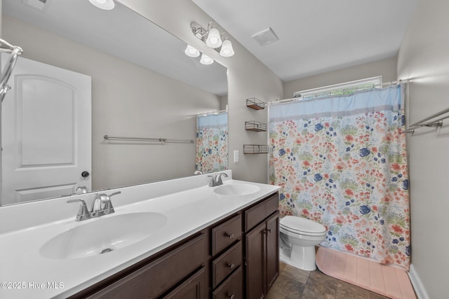 full bath with double vanity, a sink, a shower with shower curtain, and toilet