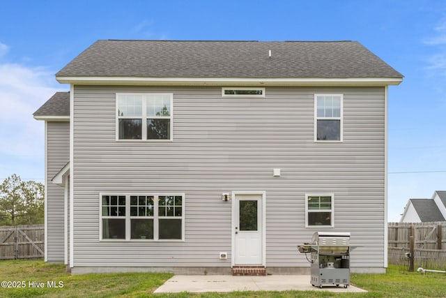 rear view of house with roof with shingles and fence