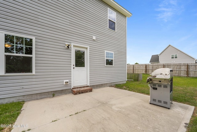rear view of house featuring a yard, fence, and a patio area