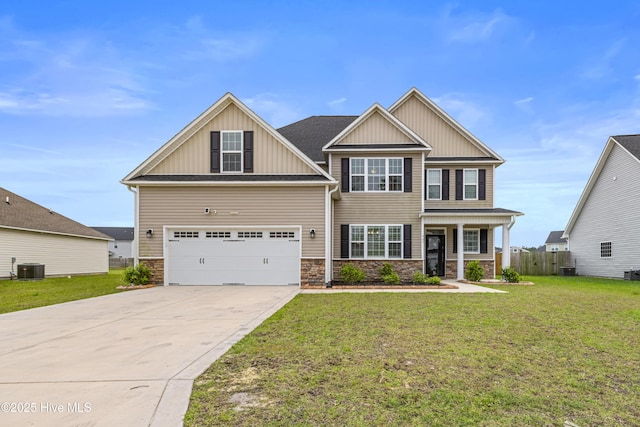 craftsman-style house featuring board and batten siding, stone siding, driveway, and a front yard