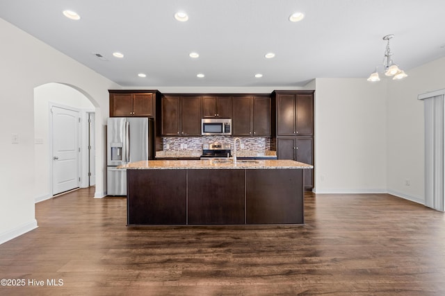 kitchen featuring dark brown cabinetry, appliances with stainless steel finishes, dark wood-style floors, and visible vents