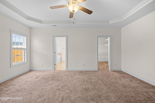 unfurnished bedroom with visible vents, ornamental molding, a raised ceiling, and light carpet