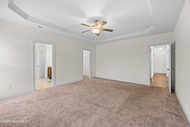 unfurnished bedroom with crown molding, light carpet, a raised ceiling, attic access, and visible vents