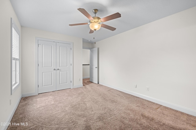 unfurnished bedroom with a ceiling fan, baseboards, carpet, and a closet