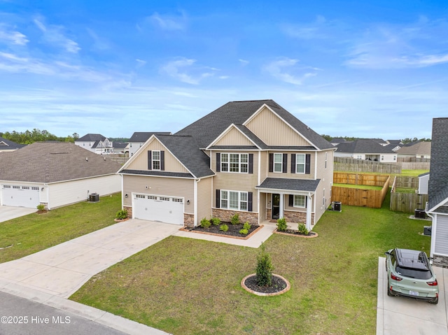 view of front of house with a front yard, fence, driveway, and stone siding