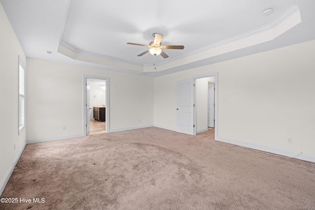unfurnished room featuring crown molding, light carpet, baseboards, a raised ceiling, and a ceiling fan