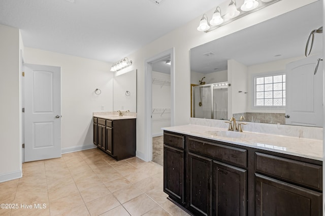 bathroom featuring baseboards, a sink, tile patterned floors, and a shower stall