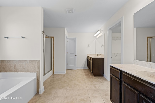 full bathroom with a sink, tile patterned floors, a shower stall, and visible vents