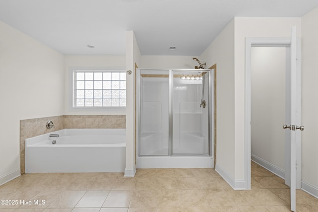 full bath with tile patterned flooring, a bath, baseboards, and a stall shower