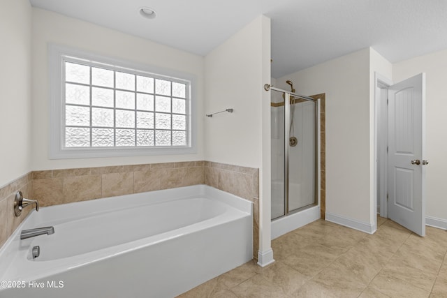 full bath featuring tile patterned flooring, a garden tub, and a stall shower
