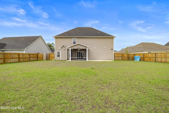 back of property featuring a yard, a fenced backyard, and a sunroom