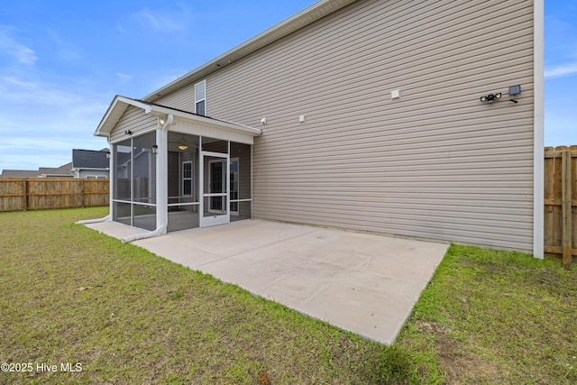 back of property with a sunroom, a fenced backyard, a lawn, and a patio