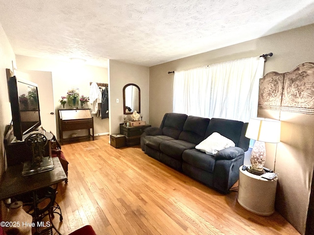 living area with light wood-style floors and a textured ceiling