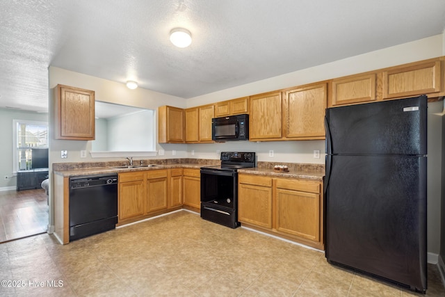 kitchen featuring a sink, a textured ceiling, brown cabinets, and black appliances