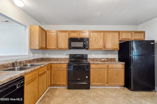 kitchen featuring light countertops, visible vents, a sink, and black appliances